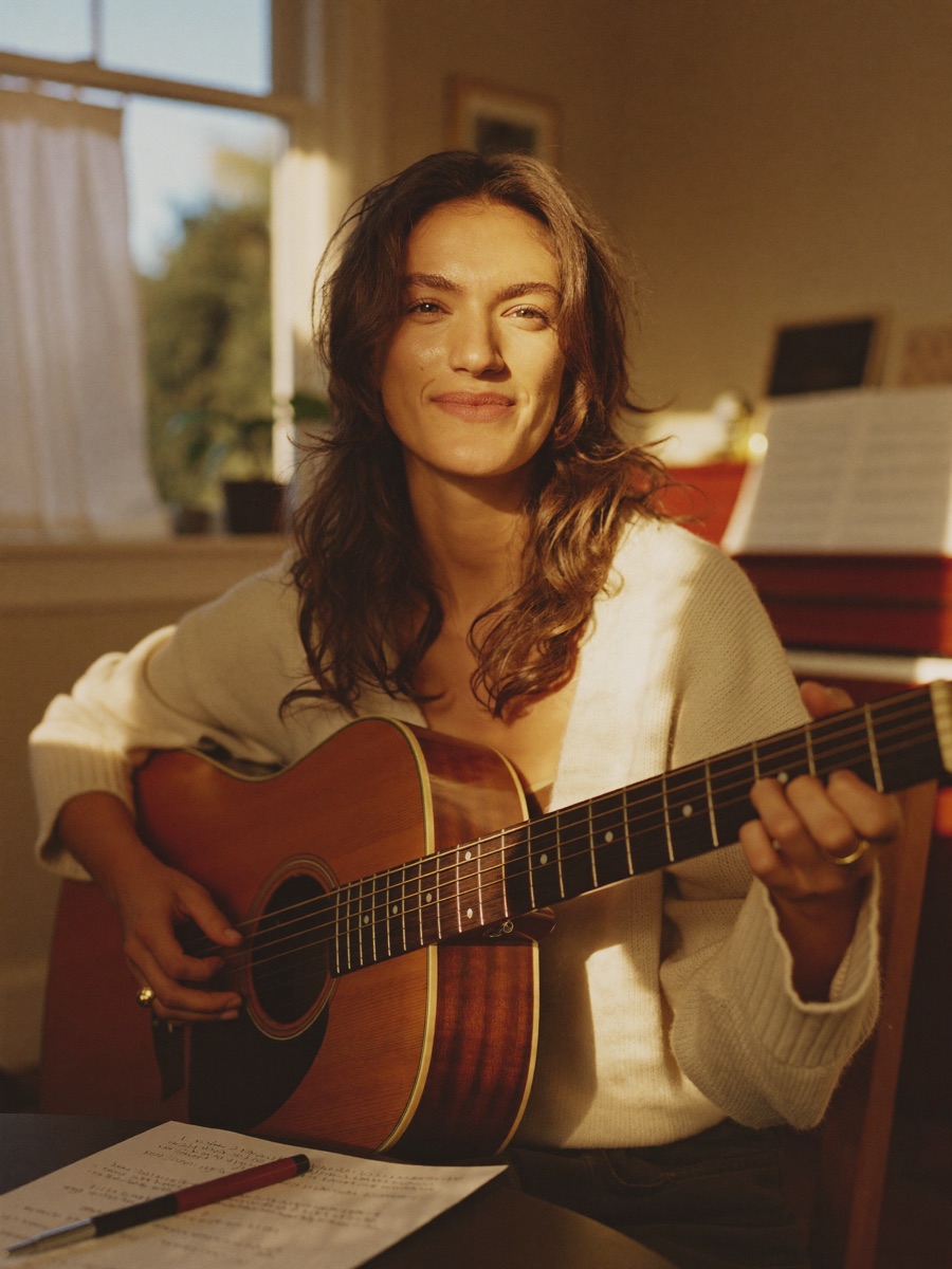 June, songwriter, in her home studio with her guitar